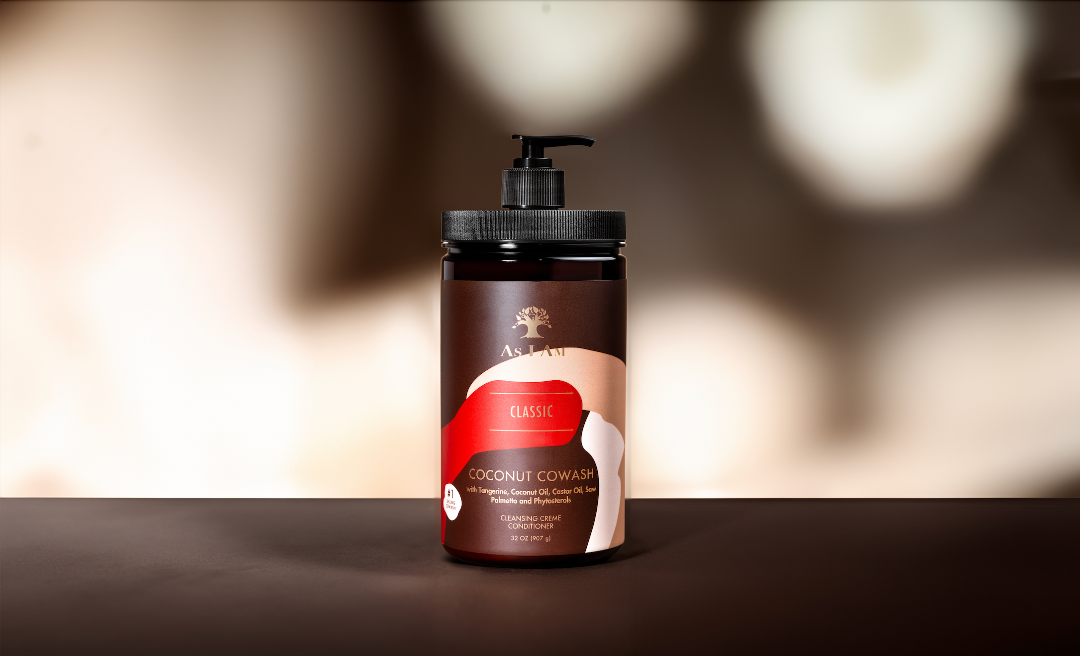 As I Am Classic Coconut CoWash in een 32oz formaat, een reinigende conditioner die is ontworpen om zachtjes opbouw te verwijderen terwijl het vochtgehalte behouden blijft en de kruldefinitie verbetert.