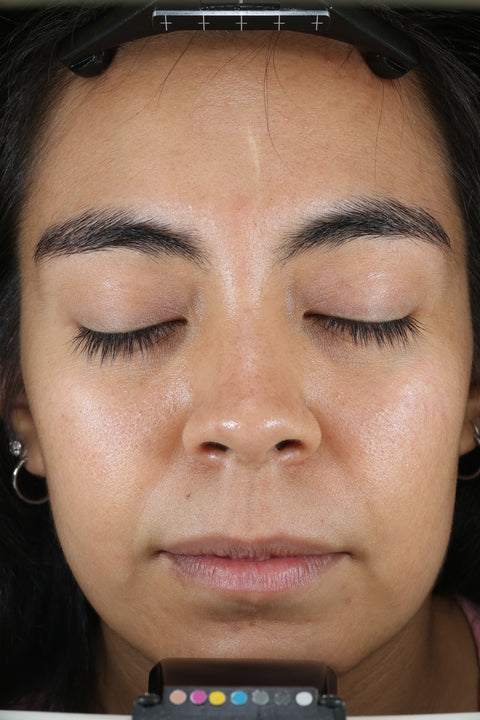 Close-up van het gezicht van een persoon met gesloten ogen, waarbij de huidtextuur en make-up te zien zijn.